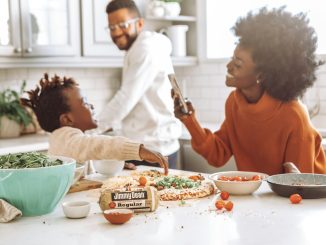 woman in red crew neck shirt holding smartphone