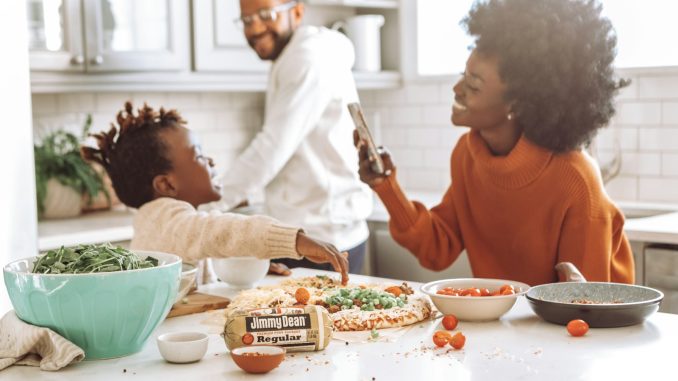 woman in red crew neck shirt holding smartphone