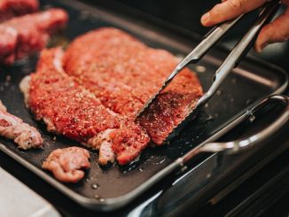 person holding stainless steel fork and steak knife