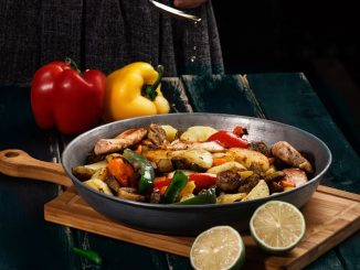 a woman in a black dress is preparing a meal