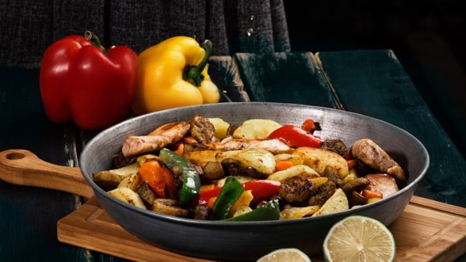 a woman in a black dress is preparing a meal