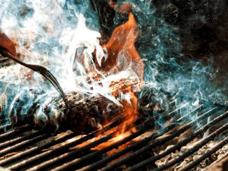 person cooking on grill with fire