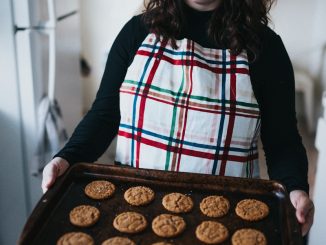 woman in black cardigan holding chocolate cake