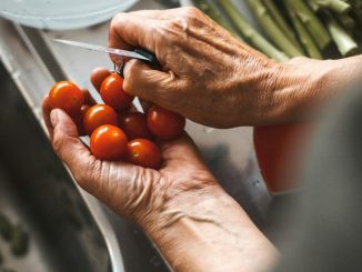 person holding knife and tomatoes