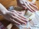 person holding dough on brown wooden table