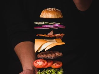 timelapse photo of man holding burger
