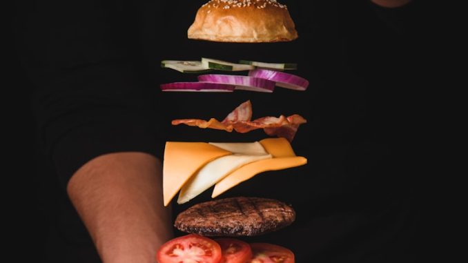 timelapse photo of man holding burger