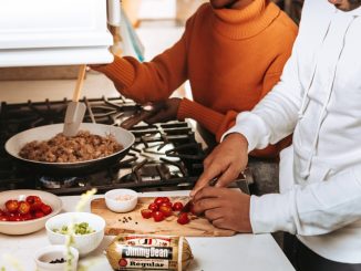 woman in orange turtleneck sweater holding brown bread