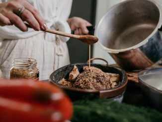 person holding brown wooden ladle