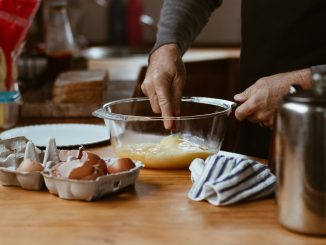 person holding clear glass bowl with brown liquid