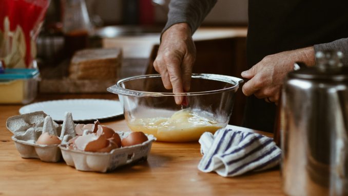 person holding clear glass bowl with brown liquid