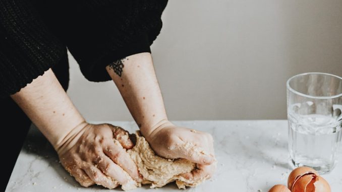 person in black long sleeve shirt holding brown chicken egg