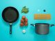 flat lay photography of frying pan beside tomatoes on blue surface