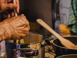 person holding brown wooden rolling pin