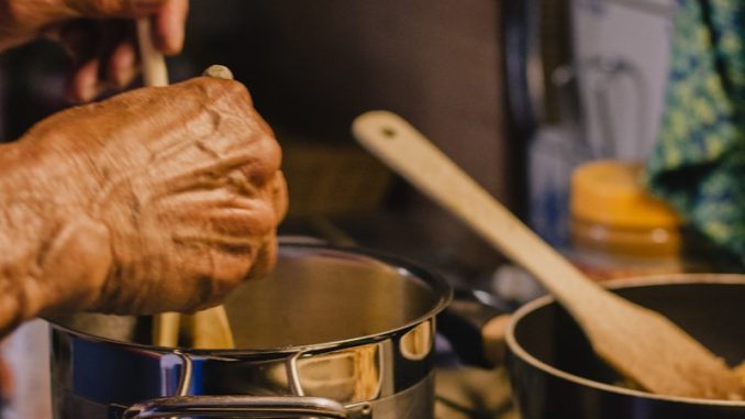 person holding brown wooden rolling pin