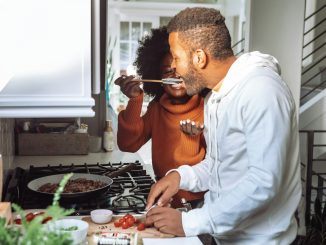 man in white and orange long sleeve shirt holding chopsticks