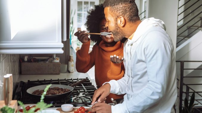 man in white and orange long sleeve shirt holding chopsticks