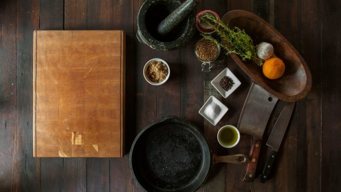 black mortar and pestle beside brown box in top view photography