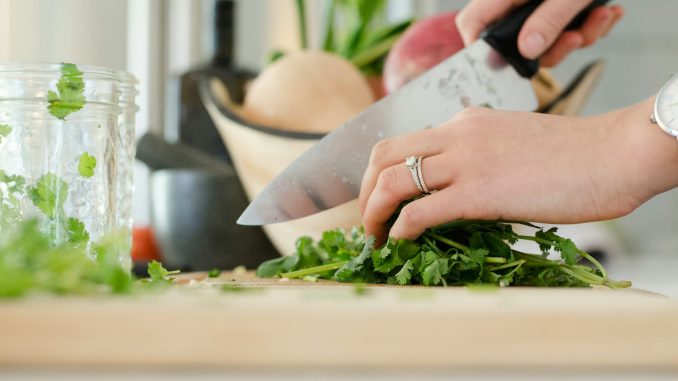 person cutting vegetables with knife
